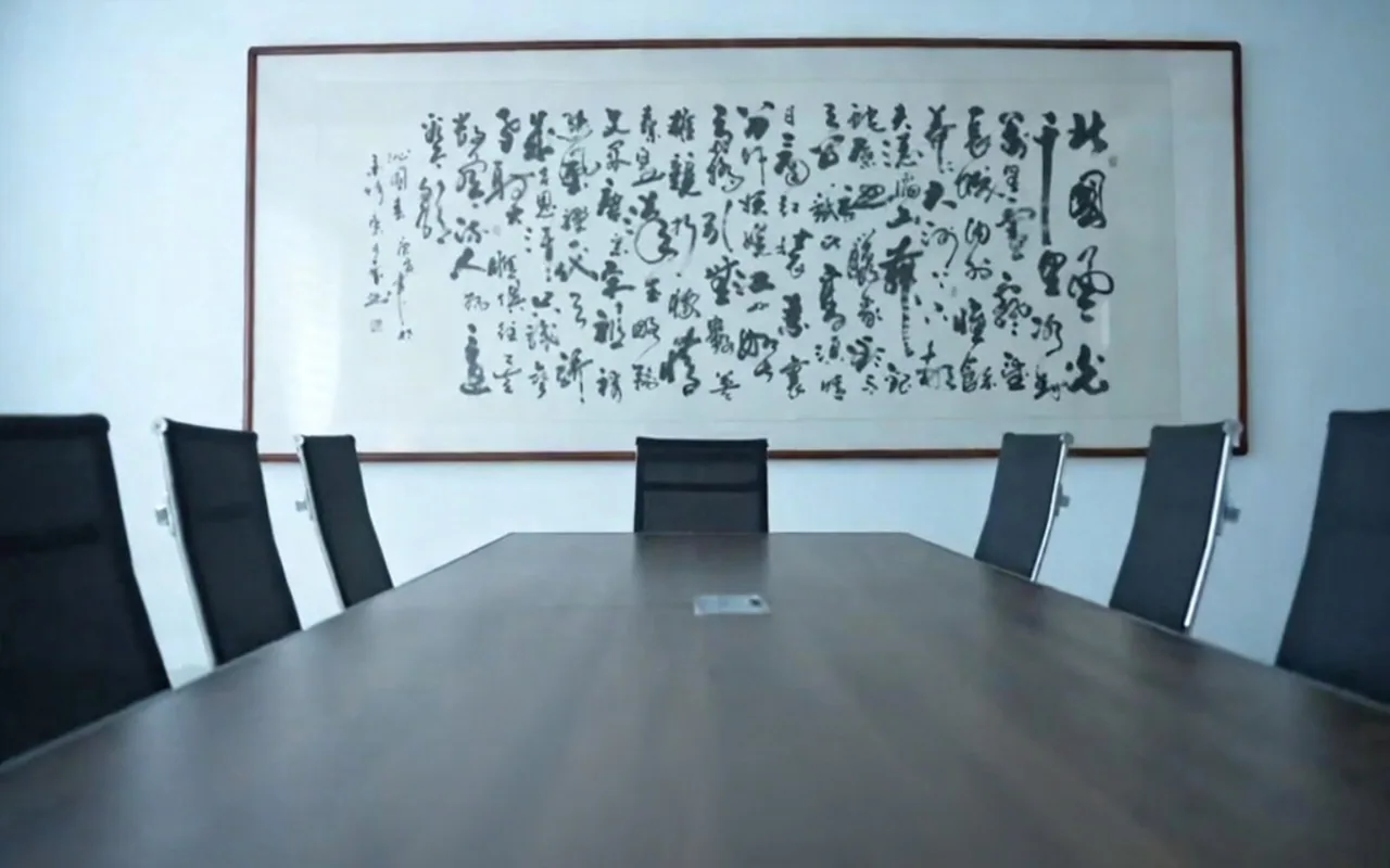 Factory meeting room with a conference table and Chinese calligraphy artwork