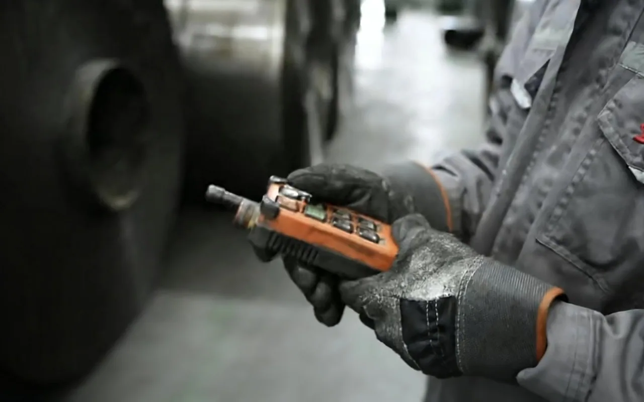 Factory operator using a handheld controller on the production line